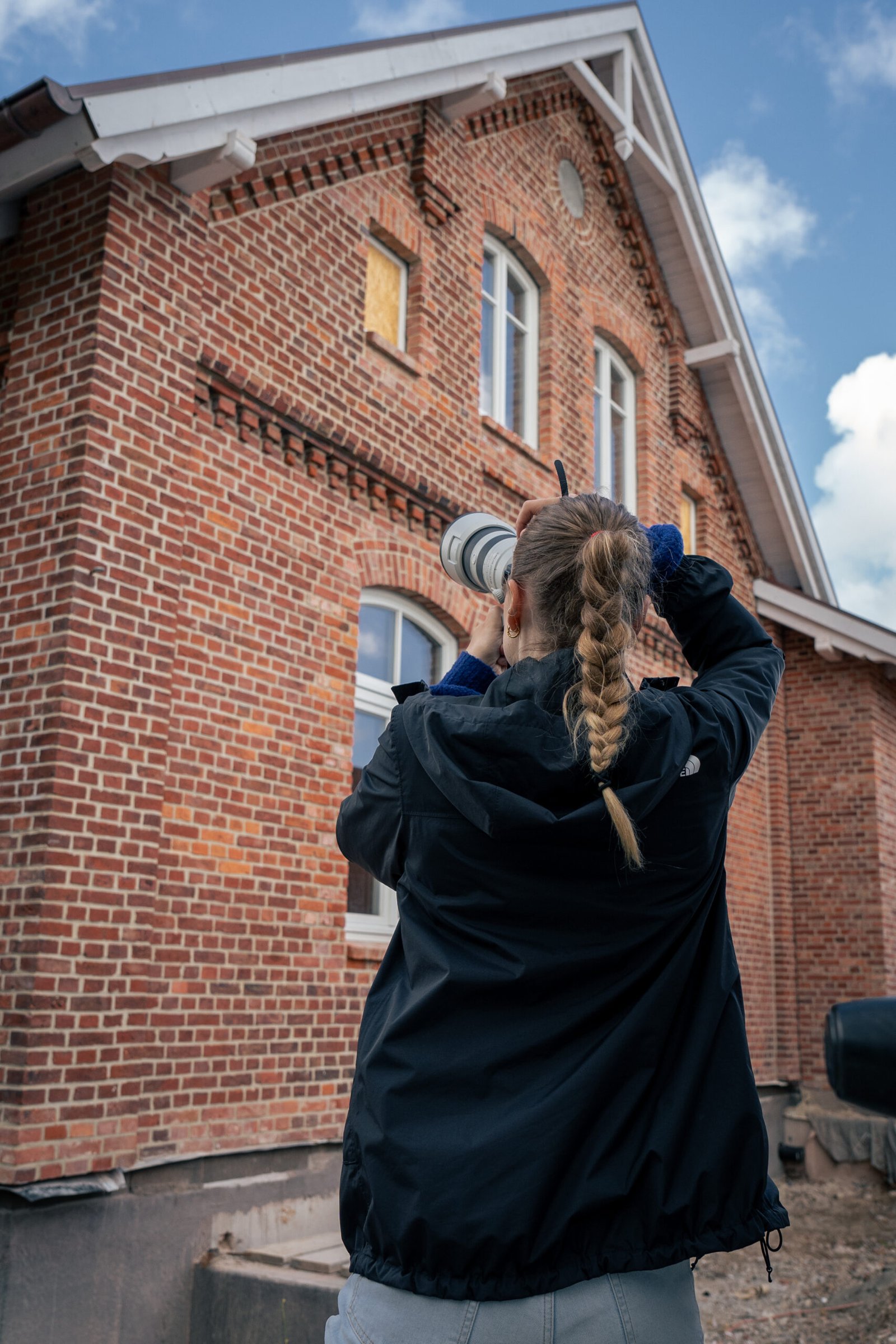Frau macht Foto vom Haus